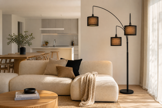 Arc floor lamp NZ — Trilogy three-light black arc over a sofa in an open-plan Kiwi lounge