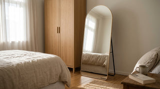 Titan Aurelia arched full length mirror 180x80cm with champagne gold frame freestanding beside an oak wardrobe in a New Zealand bedroom