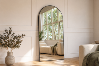 Grandeur X arched full length floor mirror with black aluminium frame leaning in a New Zealand living room