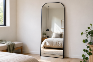 Arcadia X arched freestanding full length mirror leaning safely against a wall in a calm NZ bedroom