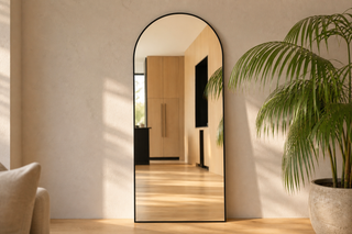 The history of mirrors, a modern Titan X arched full length mirror returning a crisp true reflection in a sunlit New Zealand living room