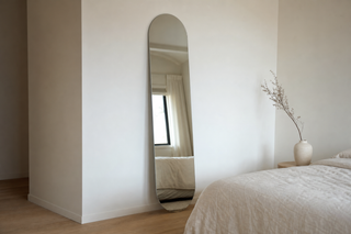 Eclipse oval frameless full length mirror leaning in a NZ bedroom — oval mirror NZ