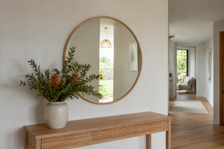 Round mirror NZ — 100cm natural wood frame round wall mirror above an oak console in a calm New Zealand entryway