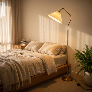 Aurelia Pleated Fabric Floor Lamp casting a soft warm glow beside the bed in a cosy bedroom