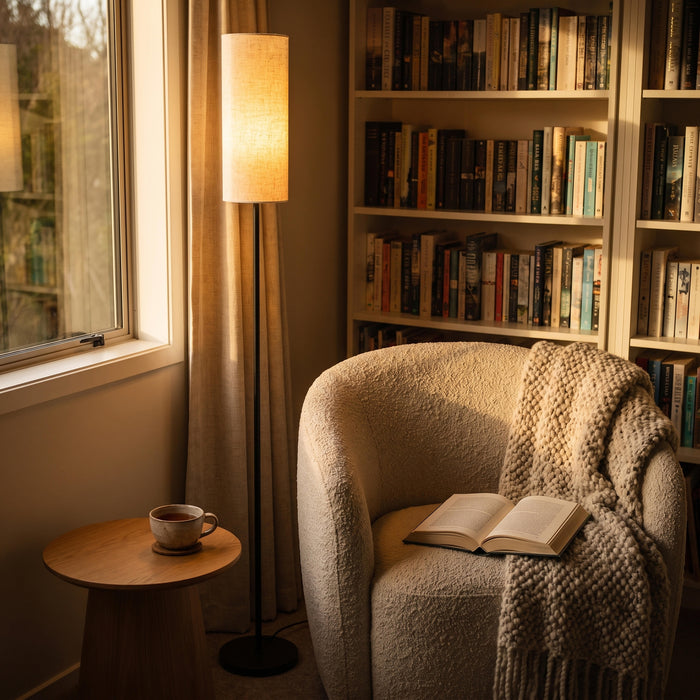 Chandelle Linen Column Floor Lamp lighting a comfortable armchair in a quiet reading corner