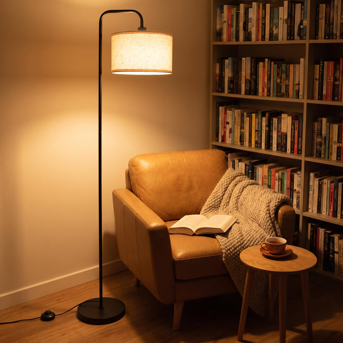 Marceau Linen Drum Floor Lamp arching over an armchair in a quiet reading corner