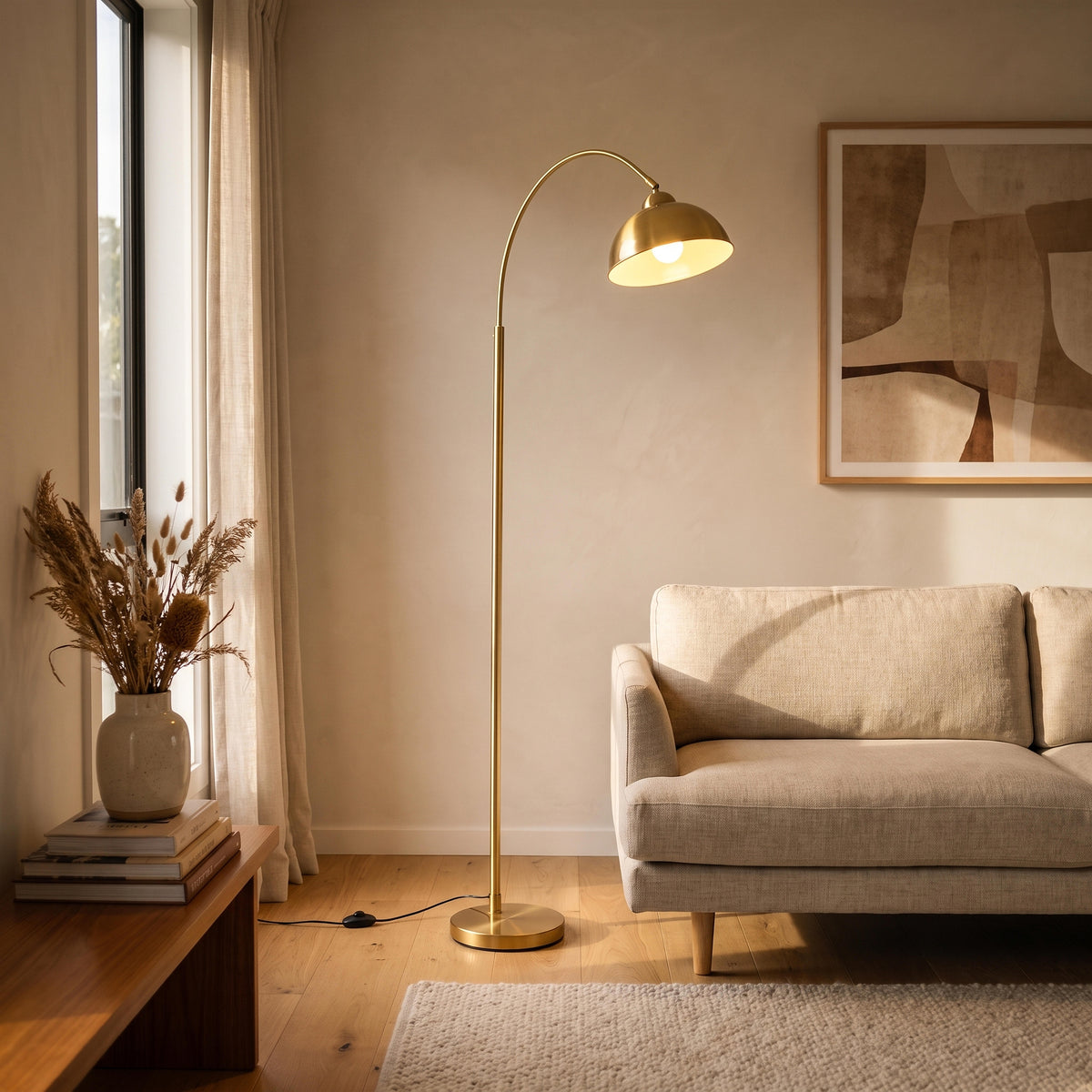 Orsay gold arc floor lamp glowing beside a sofa at night