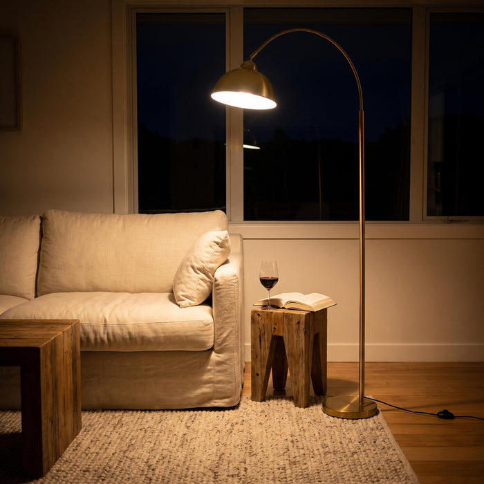 Orsay Gold Arc Floor Lamp switched on in the evening, filling the room with warm night light
