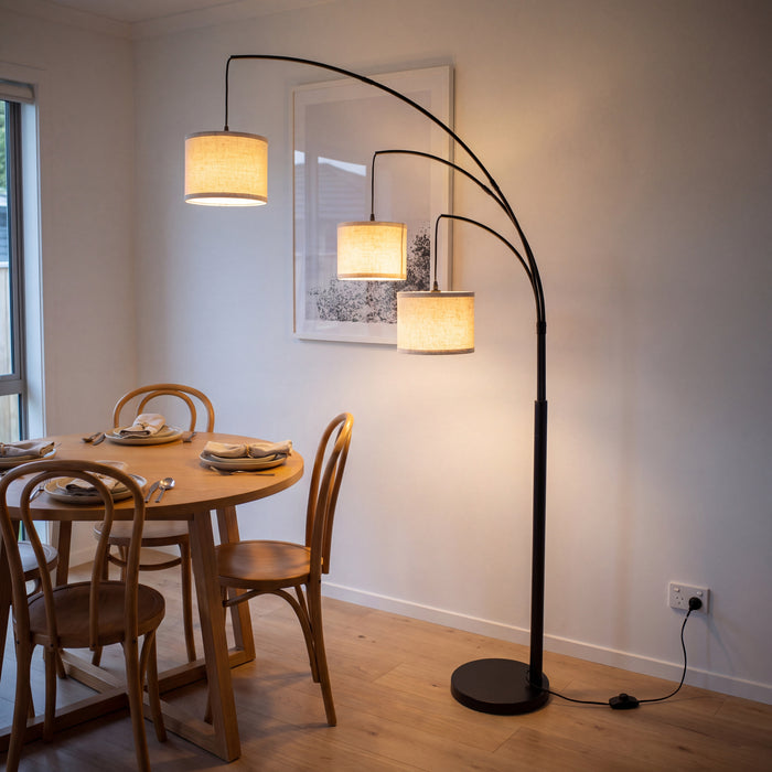 Trilogy 3-Light Floor Lamp spreading its three shades over a round dining table in the evening