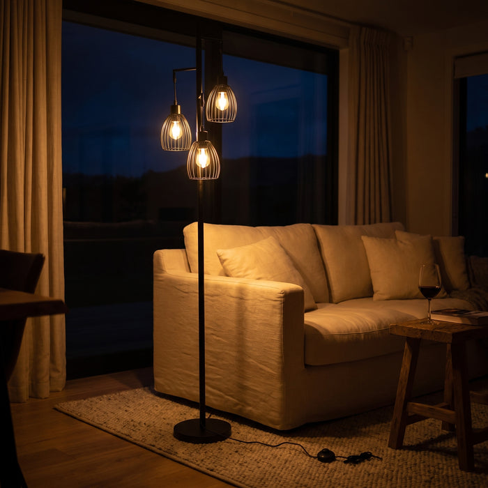 Voltaire 3-Light Cage Floor Lamp at night with all three cage lights switched on in a dark evening interior