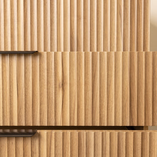 Detailed close-up of the Reede Tallboy 5-Drawer in oak finish, highlighting the vertical fluted front design, smooth texture, and modern craftsmanship.